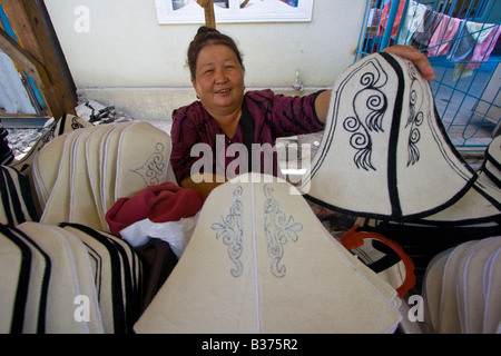 Frau verkaufen traditionelle kirgisische Hüte auf dem Markt in Osch, Kirgisistan Stockfoto