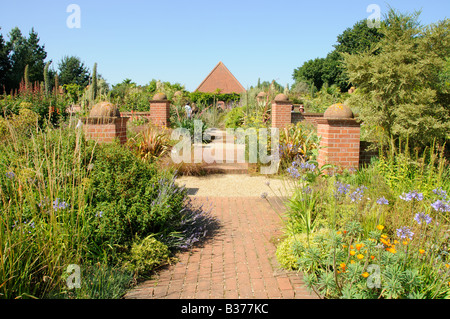 Weg mit dekorativen Stein Sockeln führt zu Ziegel Sommerhaus im großen Garten Ost Ruston Norfolk Uk Juli Stockfoto