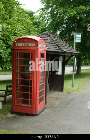 Rote Telefonzelle neben Bushaltestelle im Dorf Buckinghamshire, Großbritannien Stockfoto