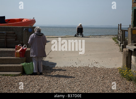 Ältere Frau im Rollstuhl, Blick auf das Meer Stockfoto
