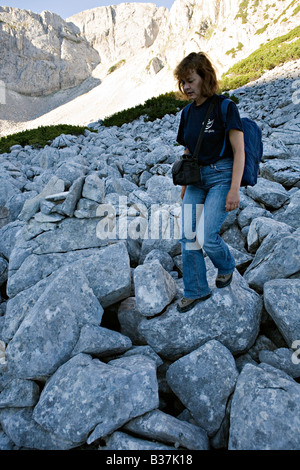 Frau zu Fuß auf großen Felsbrocken in der Nähe von Sinanitsa Berghänge in World Heritage Site Nationalpark Pirin Bulgarien Stockfoto