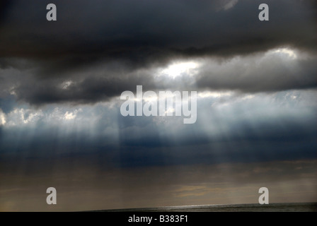 Sonnenlicht durchströmen Gewitterwolken über der französischen Küste im Sommer, Normandie, Frankreich Stockfoto