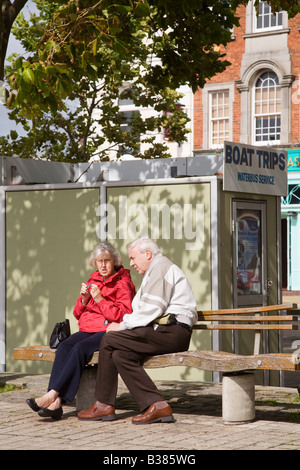 Ein älteres Ehepaar sitzt auf einer öffentlichen Bank in Portsmouth Stockfoto