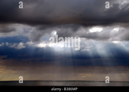 Sonnenlicht durchströmen Gewitterwolken über der französischen Küste im Sommer, Normandie, Frankreich Stockfoto