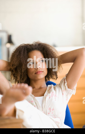 Afrikanerin mit Füße hoch auf Schreibtisch Stockfoto