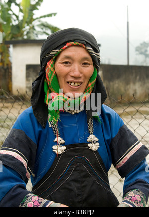 Glücklich lächelnd schwarze Hmong Frau, die traditionelle Tracht auf einem Markt in Nordvietnam trägt Stockfoto
