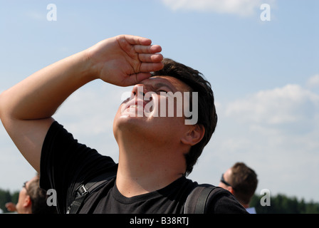 Junger Mann, Blick in den Himmel auf einer airshow Stockfoto