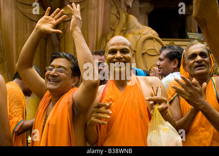 Jain Pilger in Regen und Farbe getränkt tanzen an den Füßen der Statue von Lord Bahubali (Gomateshwar) bei Shravanabelagola. Stockfoto