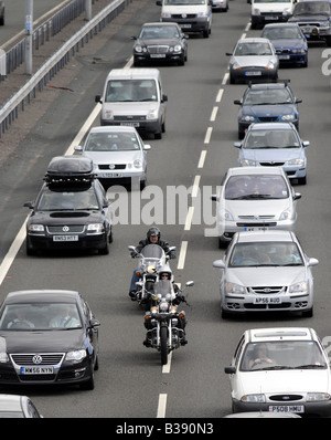 MOTORRADFAHRER, DIE FILTERUNG DURCH STARKEN VERKEHR AUF DER AUTOBAHN M6 AUTOBAHN BEI AUSFAHRT 11, CANNOCK, STAFFORDSHIRE, UK. Stockfoto