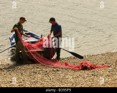 Zwei Immobilien-Arbeiter im Paxton House auf dem Fluss Tweed in der Nähe von Berwick bereiten ein Netz zum Lachsangeln Stockfoto