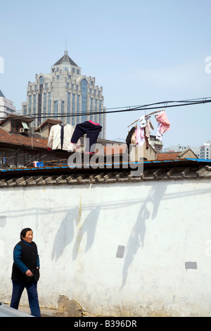 Ältere Frau Spaziergänge entlang der Straße unter Kleidung auf einer Linie. Stockfoto
