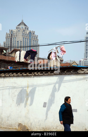 Ältere Frau Spaziergänge entlang der Straße unter Kleidung auf einer Linie. Stockfoto