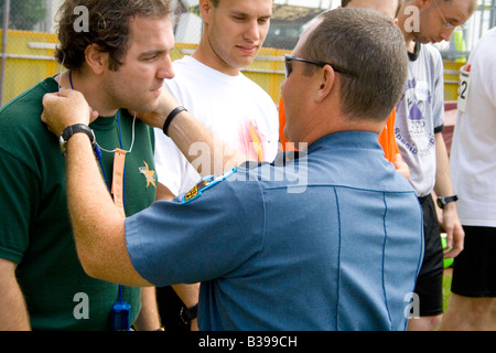 Polizist Athleten Hals Band Inverkehrbringen. Special Olympics U M Bierman athletischen Komplex. Minneapolis Minnesota USA Stockfoto