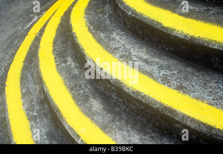 Detail der halbrunden Beton Treppe gebeizt mit Verwitterung aber mit breiten Hochsicht Gelb Farbe und Kanten Stockfoto