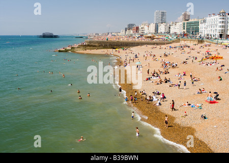 Menschen, die zum Sonnenbaden am Strand von Brighton Stockfoto