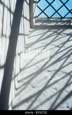 Projektion von deutlich kleiner Diamant verbleit Glasscheiben Fenster auf Seiten Creme lackiert rauhe Aussparung mit blauem Himmel sichtbar Stockfoto