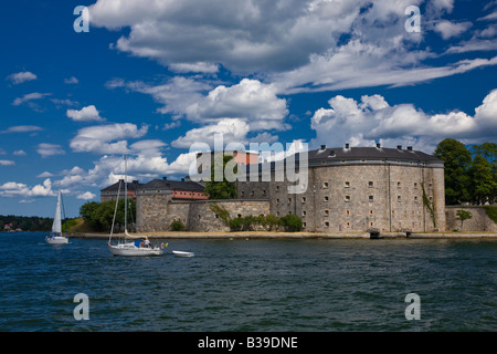 Schweden Sehenswürdigkeiten Attraktion Fort Vaxholms aus Wasser, zwei Segelboote Segeln von schönen Sommernachmittag dimensionale blauer Himmel, geschwollene cumulus Wolken Stockfoto