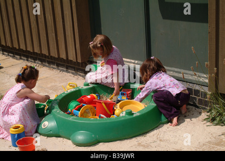 Kinder spielen zusammen in einem Kunststoff-Sandkasten Stockfoto