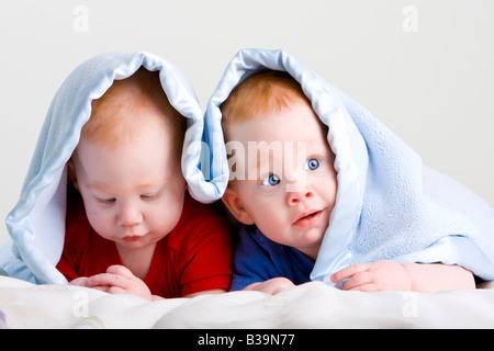 Schöne junge baby Zwillingen mit roten Haaren auf Front unter weichen Decke liegend Stockfoto