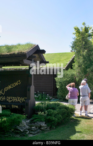 Touristen auf der Suche nach Ziegen auf der Oberseite Al Johnsons Sod überdachten restaurant Stockfoto