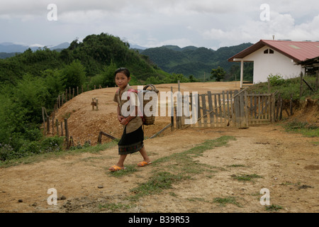 Nong Het District, Provinz Xieng Khouang, Laos. Eine Mädchen geht vorbei an ihrer Schule eröffnet, nachdem MAG Ortsbild des UXO gelöscht. Stockfoto