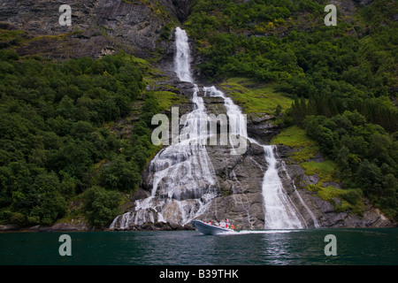 Beliebte Bridal Veil Falls, Geiranger Fjord Norwegen, lokalen kleinen Power Speed Boot Tour Wasserfälle, die mit Touristen fügt Skala zu großen hohen Wasserfall Stockfoto