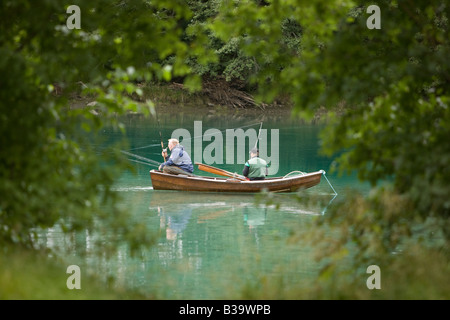 Zwei Herren genießen Sie einen ruhigen Sommer Tag Angeln aus ihrem Boot, umrahmt von Bäumen in einem Bach in der Nähe von Storfjord Noway Stockfoto