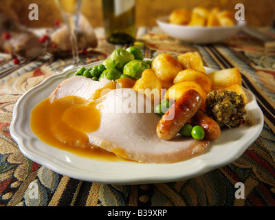 Traditionelles Truthahn-Weihnachtsessen mit allen Zutaten und Bratkartoffeln, überzogen und serviert in festlicher Tischstimmung Stockfoto
