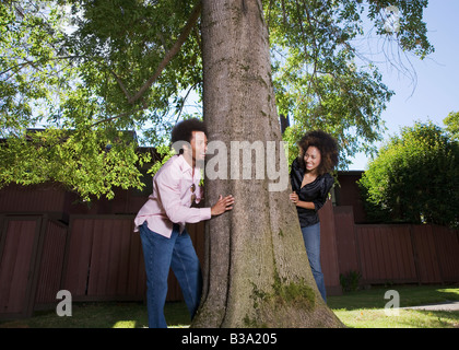 African paar spähen um Baum Stockfoto