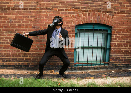Geschäftsmann, stehen neben Ziegel Wand tragen Gasmaske bei der Bekämpfung der Haltung Stockfoto