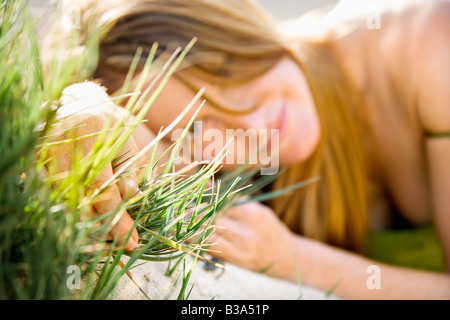 Selektiven Fokus Portrait von junge rothaarige Frau liegend Gras Viewer betrachten Stockfoto