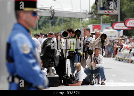 Ein lokaler Polizist blickt auf, während die Medien warten, bis die nächste Zeit trial Fahrer in Cholet-Etappe der Tour De France Stockfoto