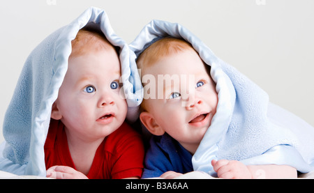 Schöne junge baby Zwillingen mit roten Haaren auf Front unter weichen Decke liegend Stockfoto