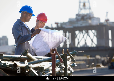 Multi-ethnischen männlichen Bauarbeiter Blaupausen betrachten Stockfoto