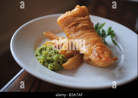 Ein Teller mit Fisch & Chips mit Erbsenpüree Stockfoto