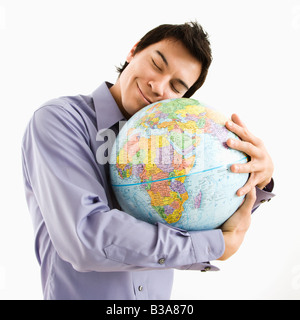 Junge asiatische Mann hält Globus mit glücklichen Ausdruck auf seinem Gesicht Stockfoto