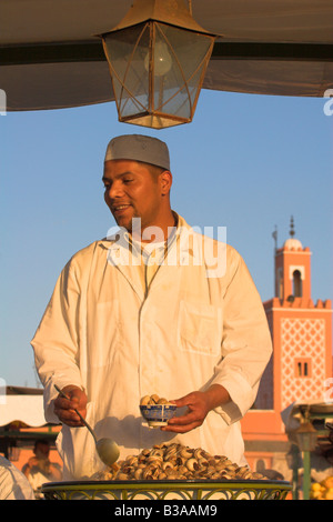 Marokko, Marrrakesh, Djemma El Fna Platz, Mann Schnecken aus Stall zu verkaufen Stockfoto