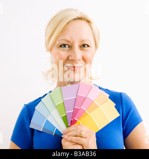 Porträt von lächelnden Erwachsenen blonde Frau mit Farbkarten Stockfoto