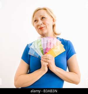 Porträt von lächelnden Erwachsenen blonde Frau mit Farbkarten mit hoffnungsvollen Ausdruck Stockfoto