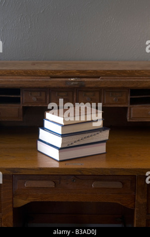 Stapel Bücher auf eine antike roll Top Schreibtisch Stockfoto