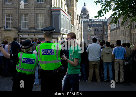 Junger Mann plaudert, zwei Polizisten, einem männlichen ein Weibchen, Hunter Square, Edinburgh, Schottland, UK, Europa Stockfoto