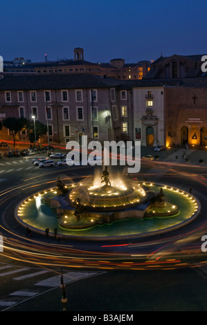 Die Autoscheinwerfer wirbeln rund um die Piazza Della Repubblica in Rom, Italien, neben dem Hotel Exedra, mit Blick auf den beleuchteten Brunnen und die Ampelwege Stockfoto