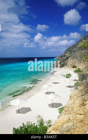 Karibik, Curacao, Niederländische Antillen, Playa Porto Marie Beach, sandigen Strand Sonnenschirme, Azure blauen Wasser. Stockfoto