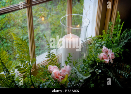 brennende Kerze im Fenster bei Hochzeit Stockfoto
