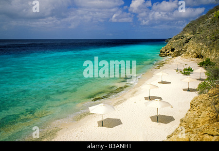 Karibik, Curacao, Niederländische Antillen, Playa Porto Marie Beach, sandigen Strand Sonnenschirme, Azure blauen Wasser. Stockfoto