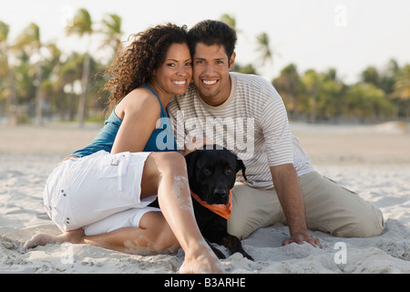 Hispanische Ehepaar und Hund am Strand Stockfoto