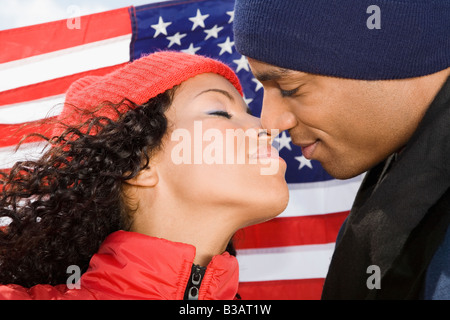 Multi-ethnischen paar küssen vor amerikanische Flagge Stockfoto