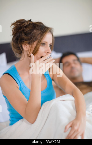 Hispanic Frau Gähnen im Bett Stockfoto