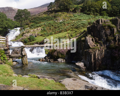 Alte Steinplatte Fußgängerbrücke über Afon Cwm Llan Wasserfall in Snowdonia-Nationalpark im Sommer in der Nähe von Bethanien Gwynedd North Wales UK Stockfoto