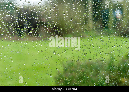 Regentropfen fallen auf ein Fenster an einem regnerischen Tag im Vereinigten Königreich Stockfoto